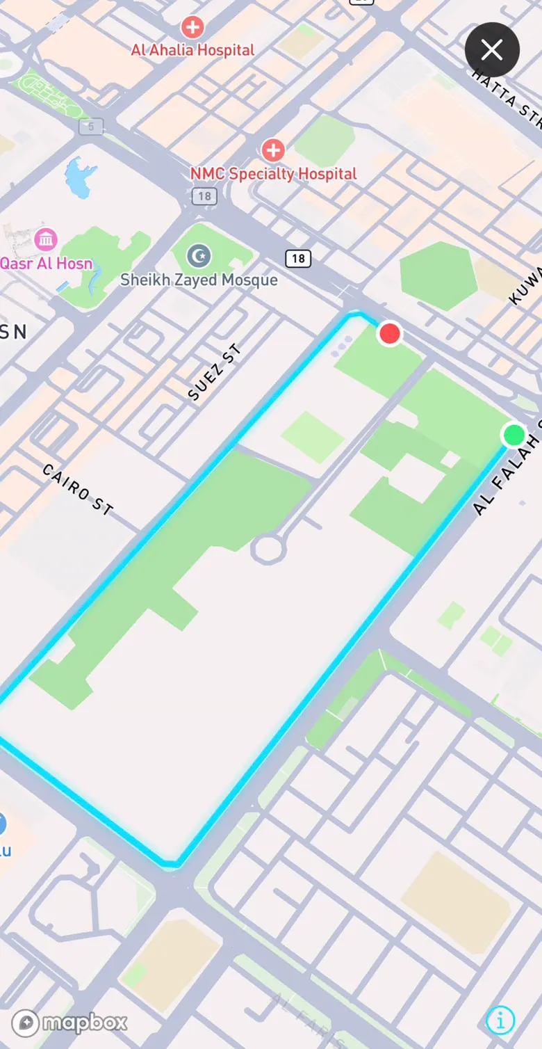 Own-it replay of a finished run flying over real terrain, the route drawn as a bright closed loop with start and finish markers on the city map.